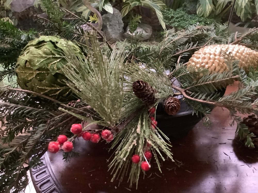 The centerpiece is built up with pine cones and Christmas balls that add fullness. The centerpiece is built up with pine cones and Christmas balls that add fullness.